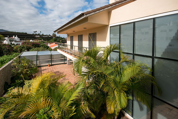 Villa Südseite mit verglaster Fassade, Terrasse und Blick zum Pool