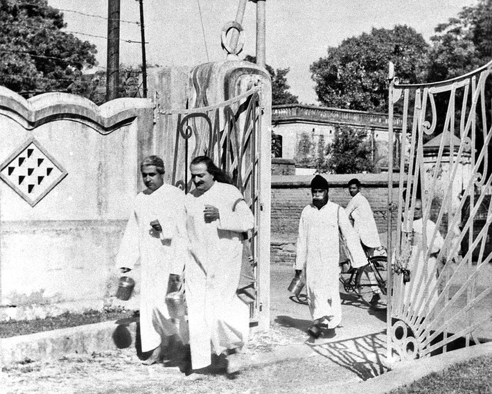  LP : 1949 - Baba begging in the New Life carry a satchel and brass pot and accompanied by Adi K. Irani with Gustadji following in Benares, India.