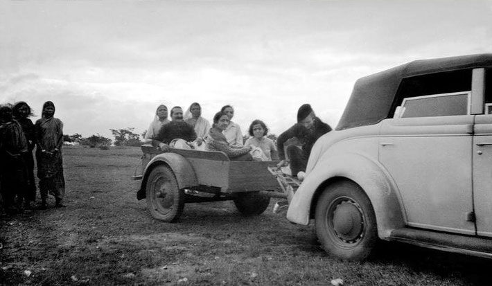  1935 Ford 4-door Auburn Deluxe Convertable Sedan with ( dickie ) rumble seat and luggage rack, which Norina is sitting on and pulling a trailer with Baba and women.