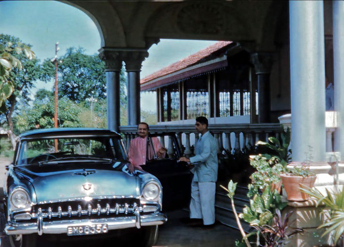 1960s : Meher Baba standing next to the DeSato car at Guruprasad, Poona, India. Eruch Jessawala is holding the door.