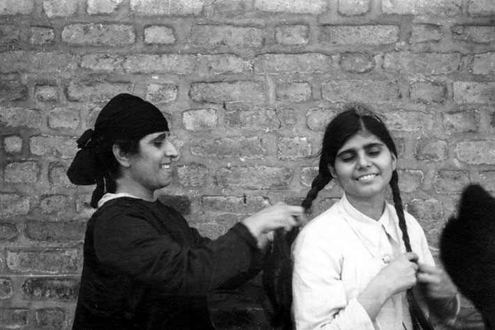  Gaimai Jessawala plaiting Manu's hair. Possibly Meherabad, late 1930's. Courtesy of the Jessawala Collection - AMB Archives, Meherabad, India.