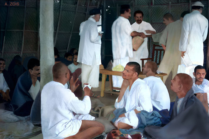 72. 1938 : Meherabad, India. Meher Baba caring for a group of Masts, with Pleader ( light hat ) & Baudul ( bucket ) assisiting him.