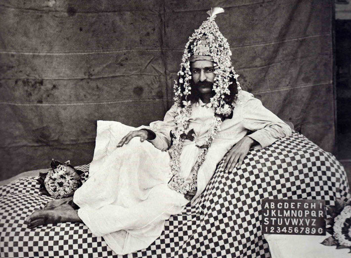 11 March 1930 : Bijapur, India. Meher Baba wearing a headress garlanded. Photographer - Narayanrao Kulkarni.