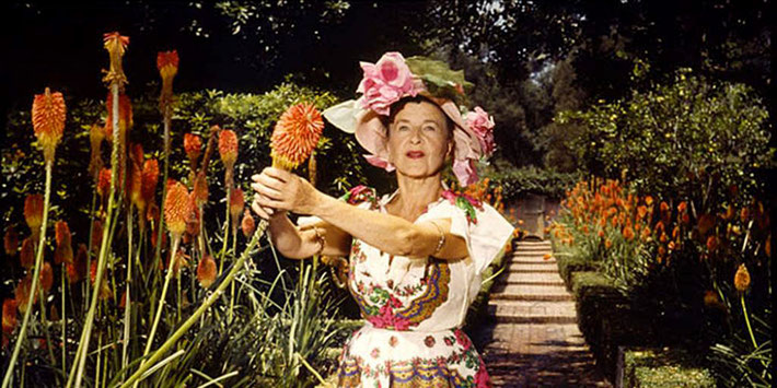 Ganna holding a red-hot poker flower in her Lotusland property.