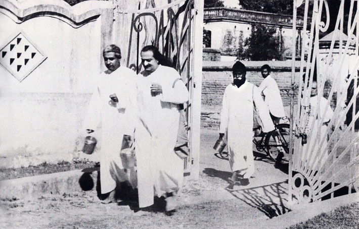 1949 - Baba begging in the New Life carry a satchel and Brass pot and accompanied by Adi K. Irani with Gustadji following.