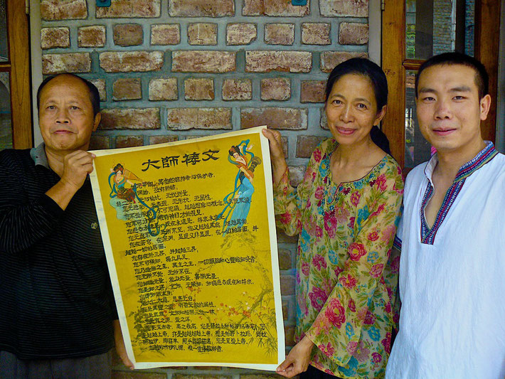 Meherabad, India - mid-2016 : Meher Baba's Master's Prayer in Chinese-Painted on silk paper by the artist Xie Guan on the left-Tian Gunther is in the center and Chen Shaubing is on the right. Photograph taken by Bil Sofer
