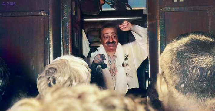Meher Baba arriving at an Indian railway station and crowds have greeted him.