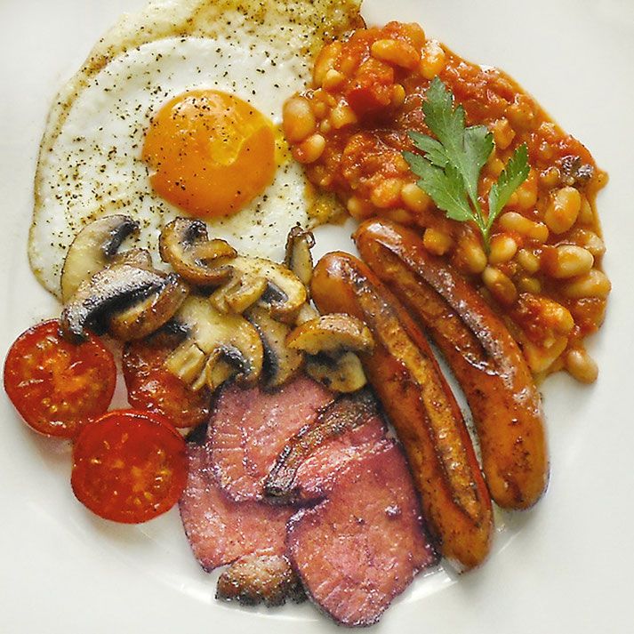 Baket Beans, gebratener Schinkenspeck und Würstchen, Setzei, gebratene Champignons u. Tomaten