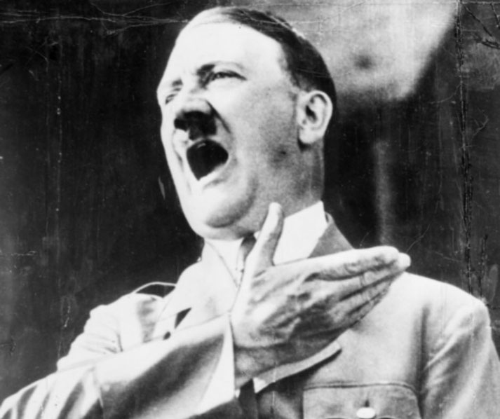 Adolf Hitler stands delivering a speech in Germany on July 16, 1940, captured mid-gesture.