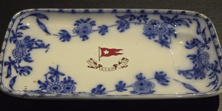 A rectangular porcelain tray with a blue floral pattern and the "White Star Line" logo featuring a red flag and banner, likely part of the Titanic's tableware collection.