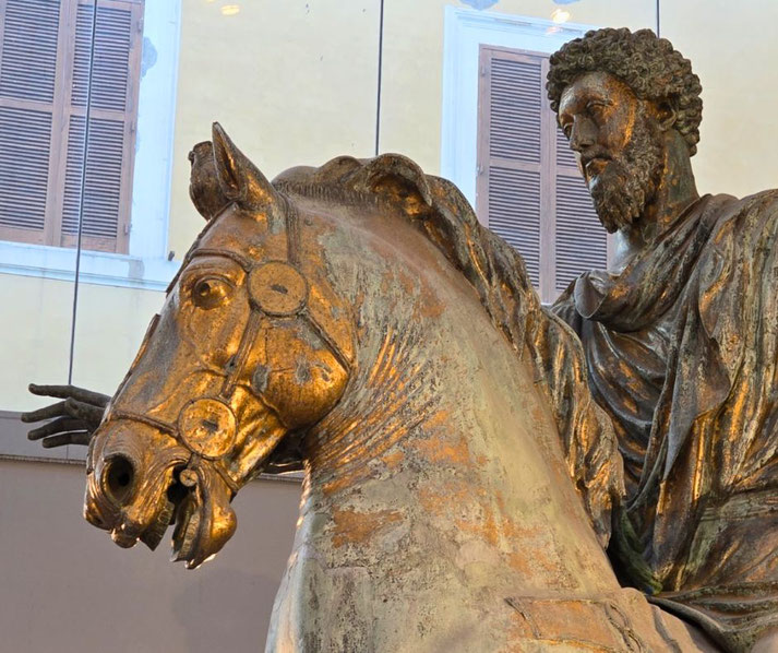 Bronze statue of a bearded man on horseback with an outstretched arm, featuring detailed drapery and horse tack.