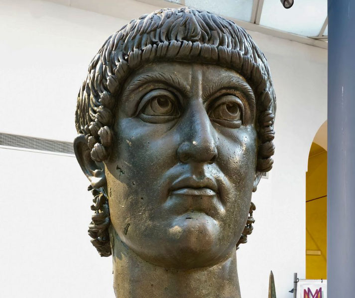 A monumental bronze head of Emperor Constantine, with large, stylized features and a distinctive hairstyle.