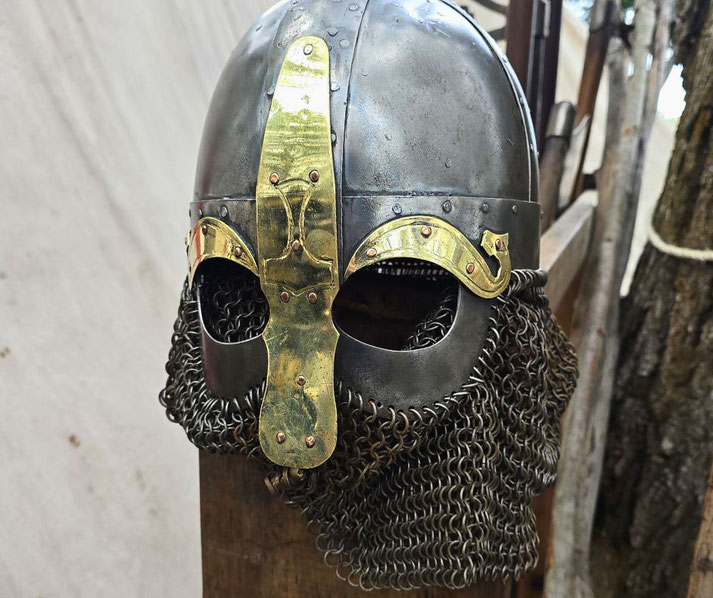A Viking-style helmet with a metal dome, brass facial guard, and chainmail aventail. 