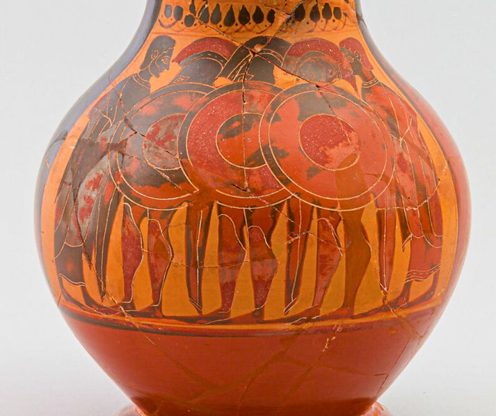 A small Archaic Greek Attic terracotta jug decorated in the black‑figure style, showing three hoplite soldiers between a man and a youth, housed at The Met in New York.