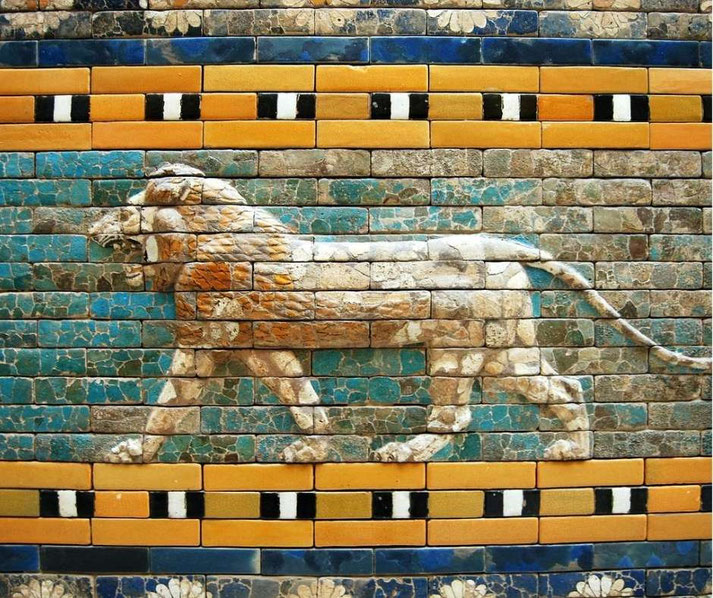 A lion relief made of glazed bricks features on a colorful ancient wall with turquoise, gold, and black accents.