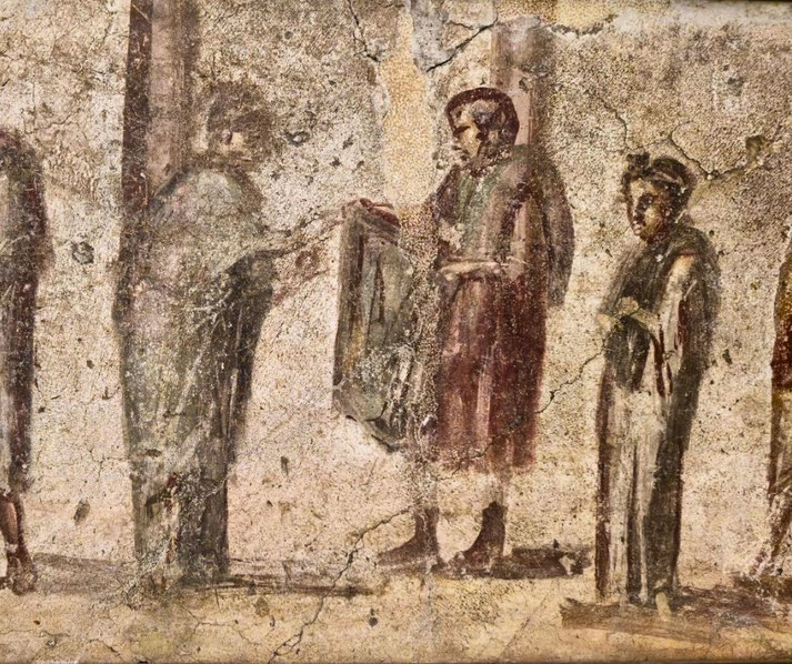Faded Roman fresco depicting four figures in conversation, with one person holding a rectangular object, possibly a tablet or cloth, against a cracked, worn wall.