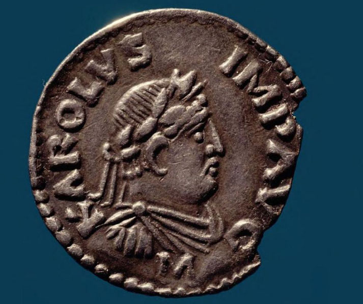 Silver coin featuring a profile portrait of Charlemagne with a laurel crown, inscribed "KAROLVS IMP AVG" around the edge.