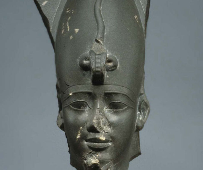 Greywacke sculpture of Osiris's head adorned with the Atef crown and uraeus, from Egypt's 26th Dynasty.