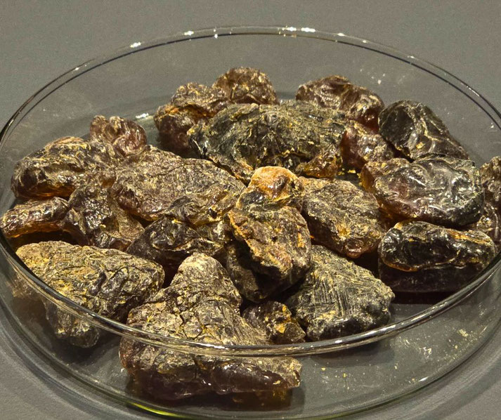 A glass dish filled with chunks of dried resin, likely myrrh or frankincense. These aromatic substances were used in ancient Egyptian mummification and religious rituals.