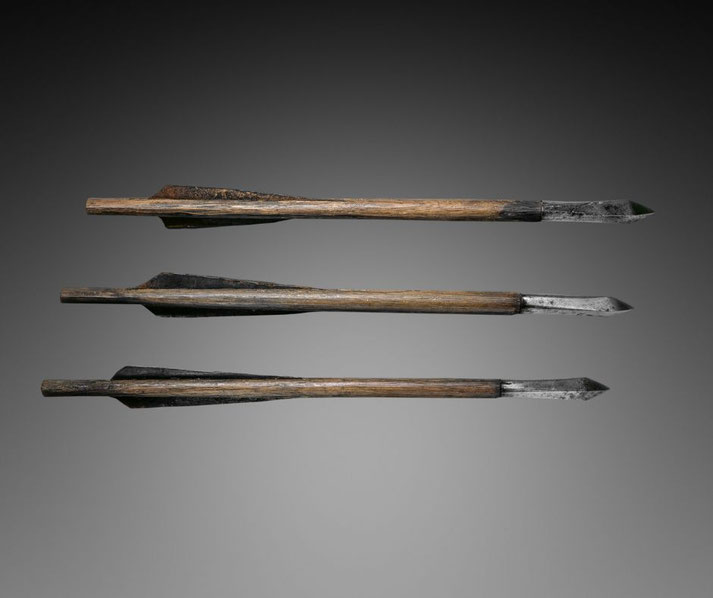 Three crossbow bolts. The points are designed for piercing, with the metal appearing worn from use, and the shafts are straight with slight variations in length.