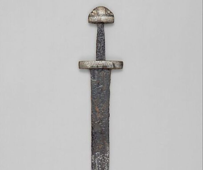 A Viking sword with a weathered blade and a decorated hilt featuring a distinctive pommel and crossguard.