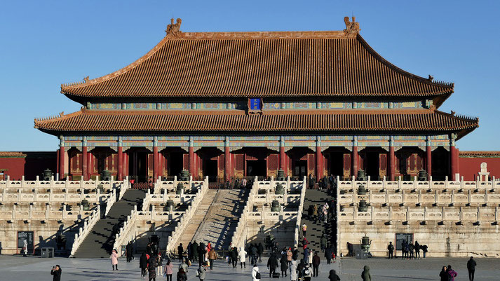 Hall of Supreme Harmony in the Forbidden City, Beijing, featuring intricate architecture, a grand staircase, and visitors exploring the historic palace under a bright blue sky.