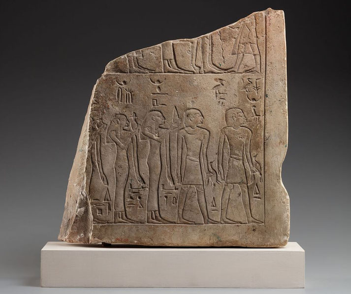 A fragment of a small limestone New Kingdom stela, bearing names linked to King Ahmose, with crescent‑moon placement dating it before his 22nd regnal year, in relief detail.