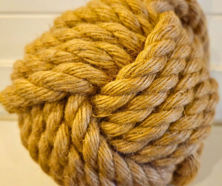 A thick, tightly woven rope tied into a large, complex knot, resembling the famous Gordian Knot.