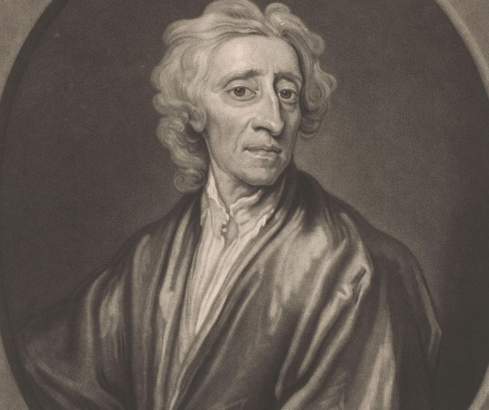 A black-and-white portrait of an older man with wavy, shoulder-length hair. He wears a loose robe over a buttoned shirt and has a serious, contemplative expression, gazing slightly to the side.