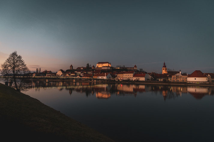 Blaue Stunde über Ptuj vom Ufer der Drau aus gesehen