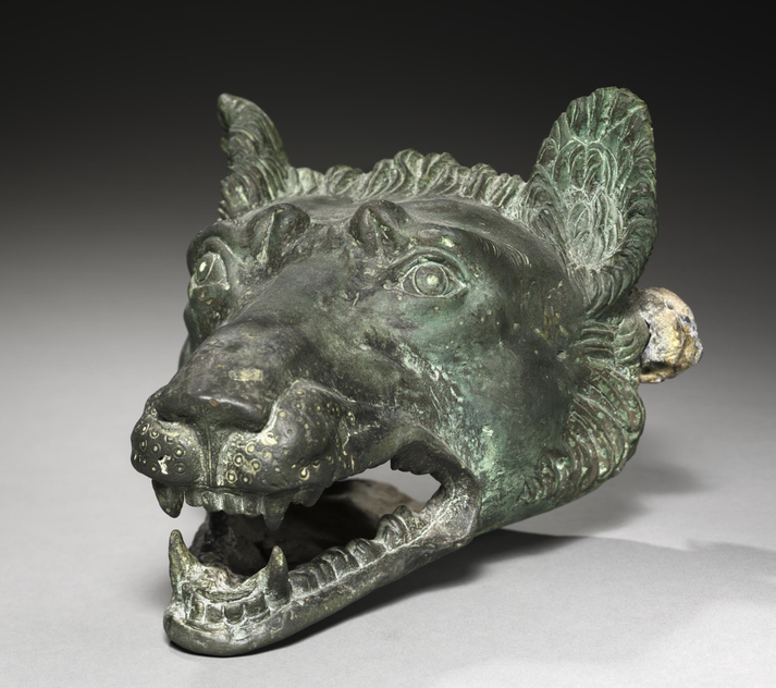 A bronze wolf head, likely a barge fixture, features intricate detailing with fierce eyes and bared teeth.