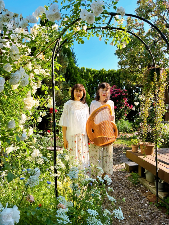 白薔薇のアーチに佇むライアーデュオ「リラ・コスモス」さん。(祥子さんの薔薇のお庭にて)