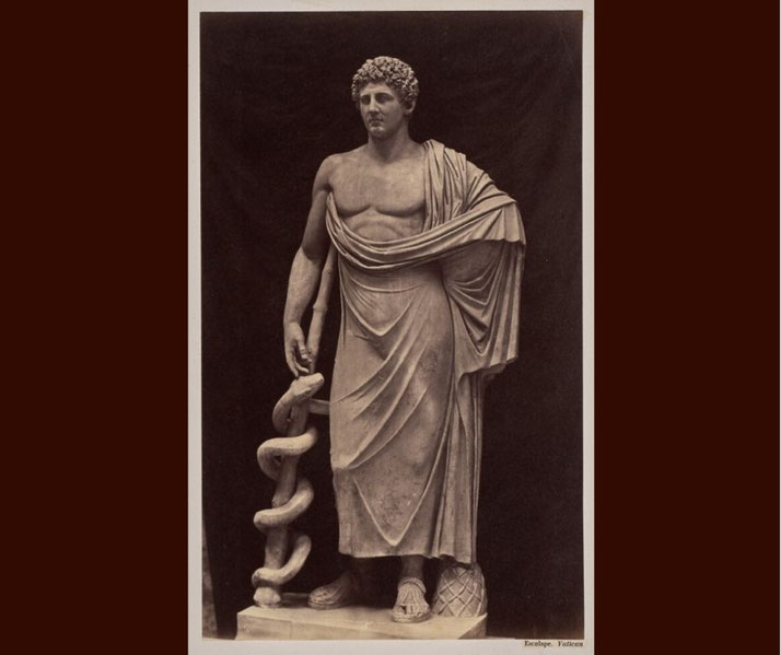 Photograph of the statue of Esculape (Asclepius) in the Vatican, shown as a classical marble figure associated with healing and medicine.