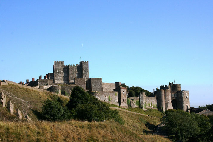 A castle situated on a hill, with multiple stone towers and walls stretching across the landscape.