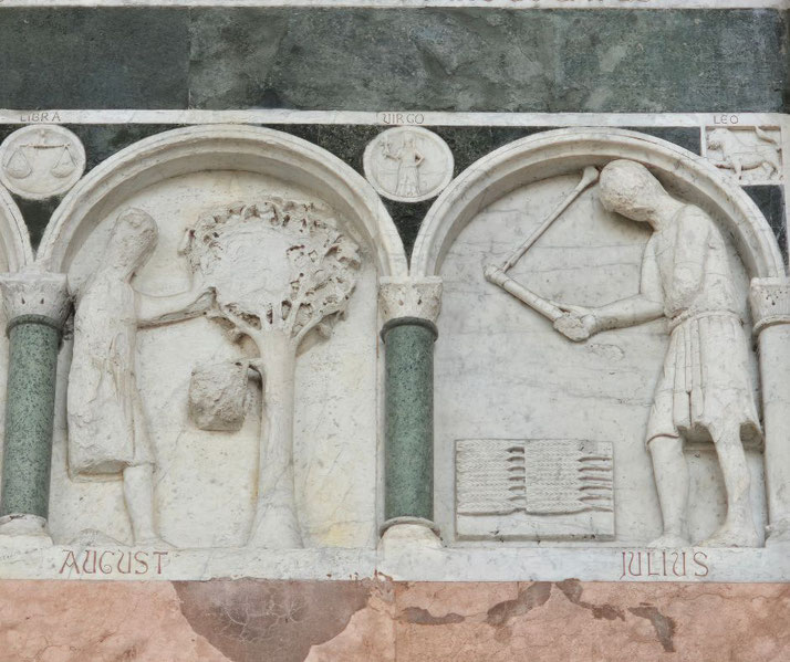 Marble relief depicts scenes labeled August and Julius: one shows a figure harvesting fruit, the other using a tool with a woven object nearby, under zodiac signs Virgo and Leo.
