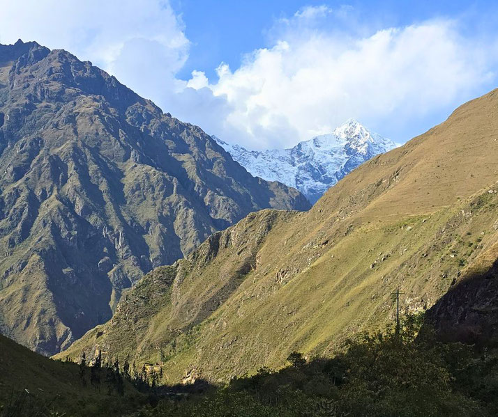 scenic view of the Andes Mountains, with lush green valleys leading to a snow-capped peak in the background.