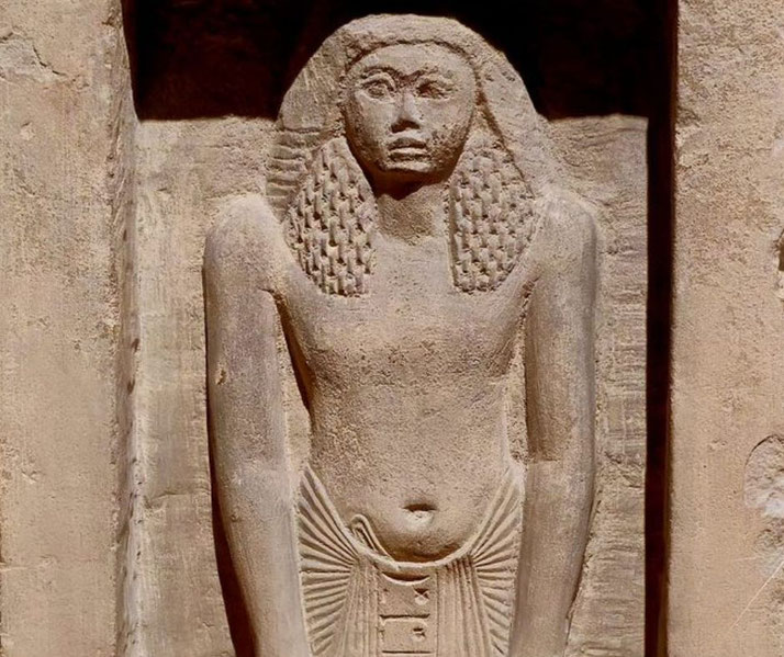 An ancient Egyptian statue carved from stone, depicting a figure with a stylized, pleated wig and traditional kilt, showcasing minimalist yet precise artistic detailing.