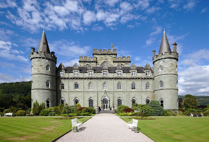 A grand stone castle with towering turrets, a large central structure, and intricate architectural details.