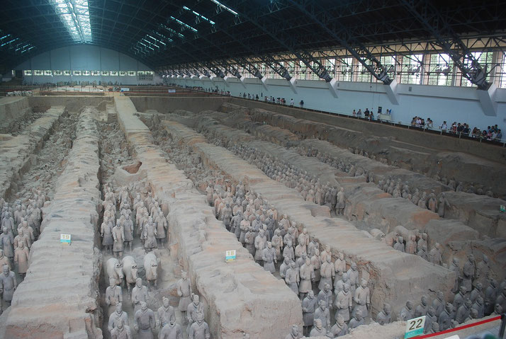 The vast excavation site of the Terracotta Army in Xi'an, China. Thousands of life-sized warriors stand in rows, preserved in a massive indoor archaeological site.