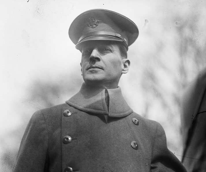 A military officer in a double-breasted coat and peaked cap looks outward, captured in a black-and-white portrait.