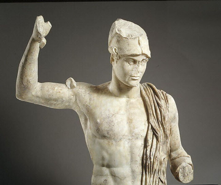 A wounded warrior, wearing a helmet and draped in a cloak. His raised arm and missing limbs suggest a dynamic battle scene.