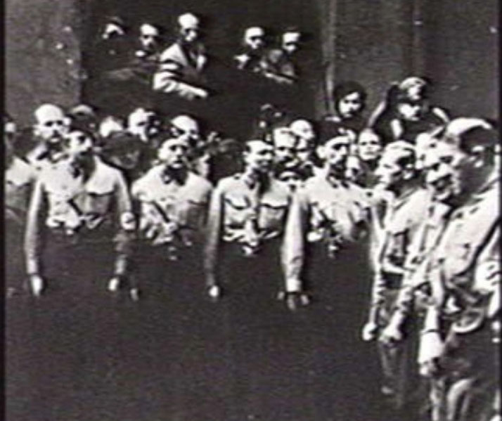 Black-and-white image showing a group of Nazi officers in uniform standing in formation during a gathering or ceremony.