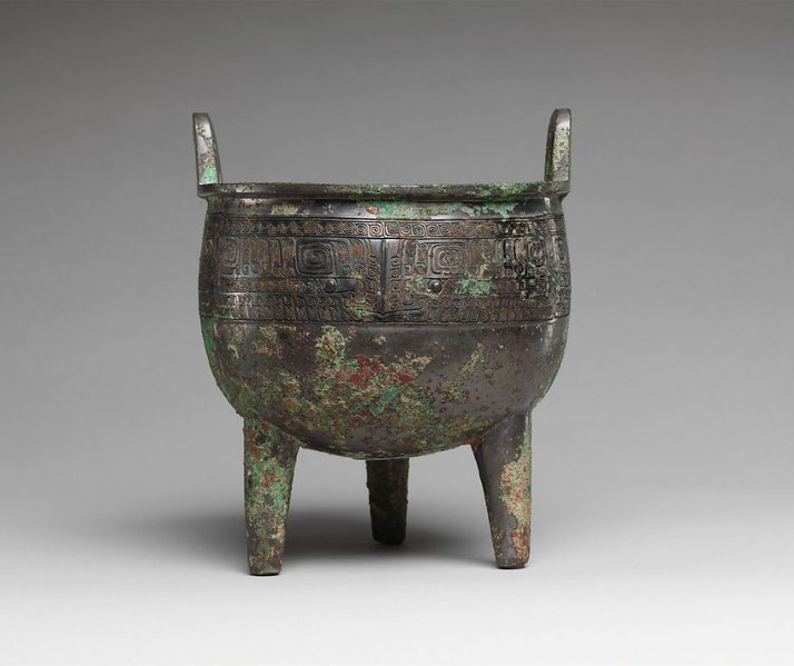 An ancient Chinese bronze tripod cauldron (Ding) with a round body, two handles, and three legs.