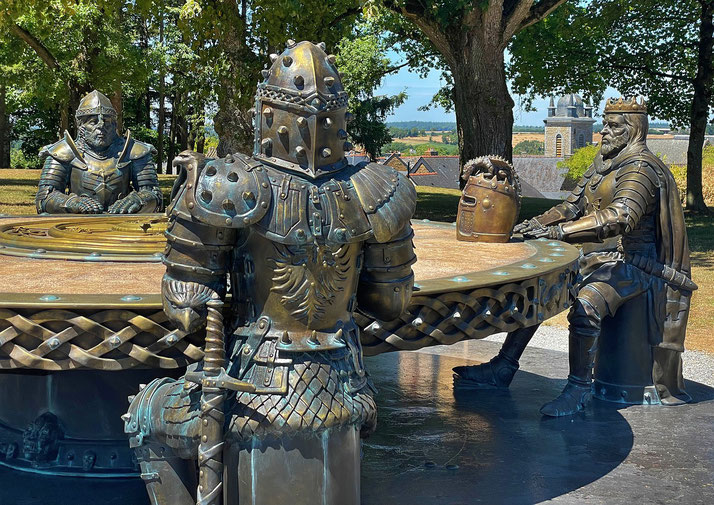 A bronze sculpture of medieval knights in armor seated around a round table, evoking the legend of King Arthur and his knights.
