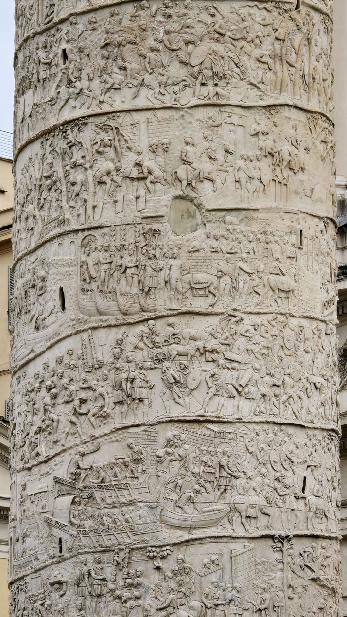 Stone carvings spiral around the column, showing Roman soldiers in battle, on horseback, transporting goods, building, and engaging in ceremonies and maritime scenes.