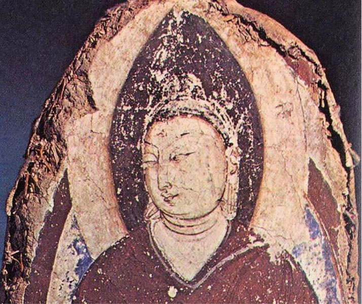 An ancient painted depiction of Buddha, with a serene expression and a halo-like background.