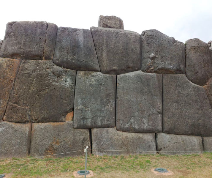 A close-up view of the massive stone walls of Sacsayhuamán, an ancient Inca fortress in Peru. The precisely-cut, tightly-fitted stones showcase impressive engineering without the use of mortar.