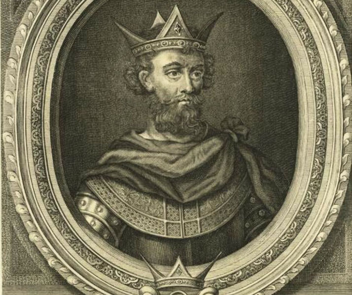 An antique engraving of a bearded king wearing an ornate crown and detailed armor, framed within an oval border.