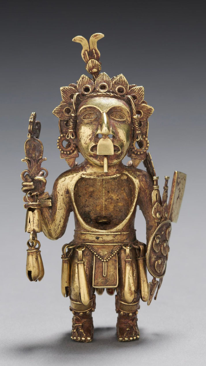 A gold figurine of a warrior, possibly from a Mesoamerican or South American culture. It features intricate details, including a headdress, shield, and ornaments, symbolizing status and power.