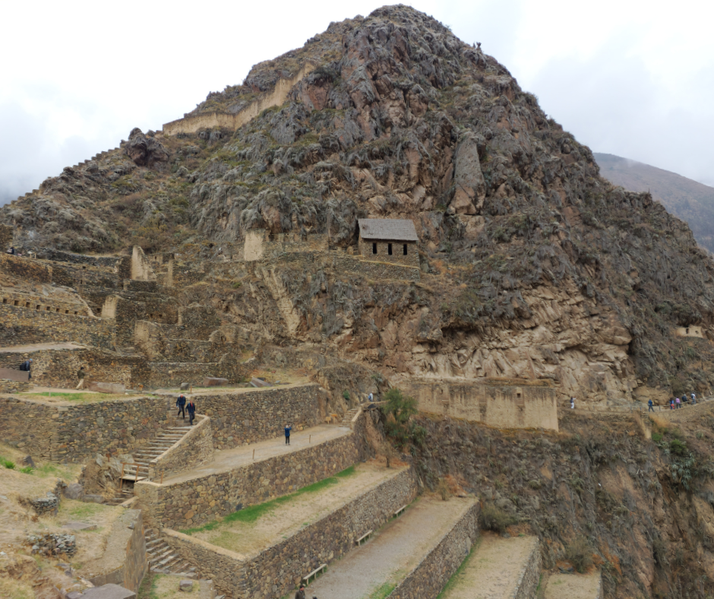 Incan ruins of Ollantaytambo in Peru, featuring stone terraces built into a steep mountainside.